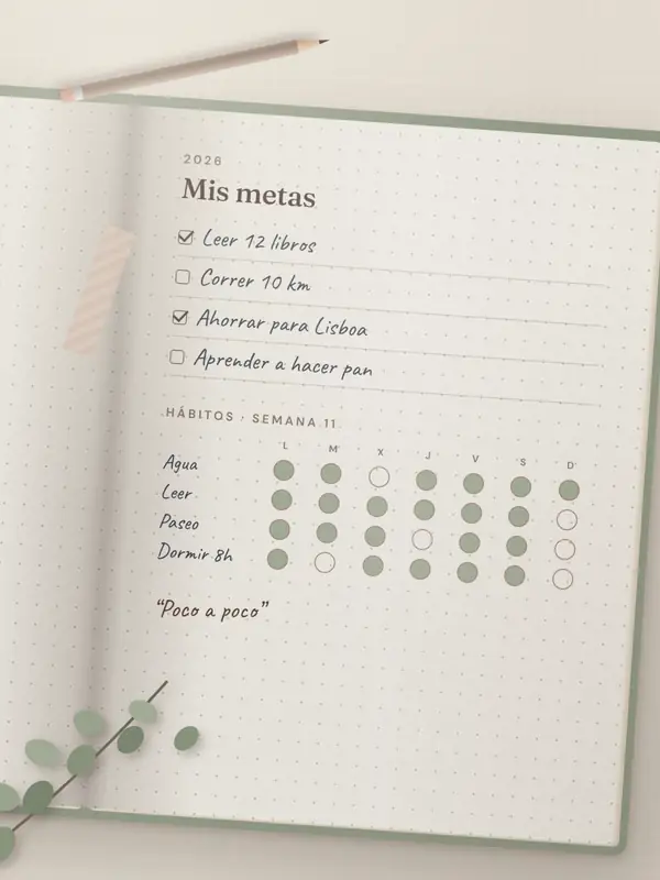 Agenda Planora abierta con lista de metas escrita a mano y seguimiento semanal de hábitos